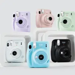 Kolorowe aparaty Instax Mini 11, idealne jako aparat dla dziecka. Różowy, fioletowy, miętowy, niebieski, biały i czarny.