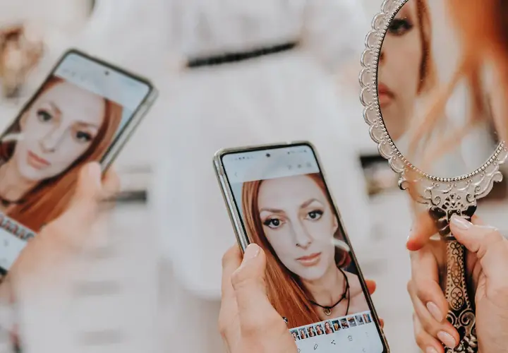 Kobieta ogląda swoje zdjęcia na telefonie, zastanawiając się, ile trwa wywołanie zdjęć u fotografa.