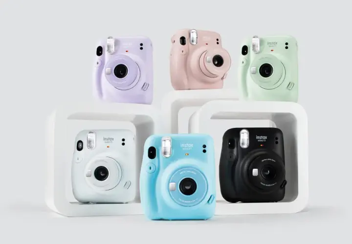 Kolorowe aparaty Instax Mini 11, idealne jako aparat dla dziecka. Różowy, fioletowy, miętowy, niebieski, biały i czarny.