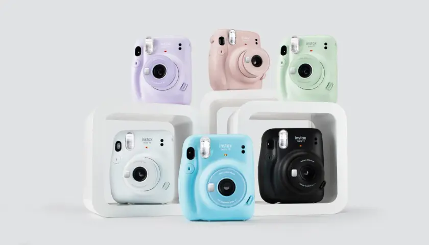 Kolorowe aparaty Instax Mini 11, idealne jako aparat dla dziecka. Różowy, fioletowy, miętowy, niebieski, biały i czarny.