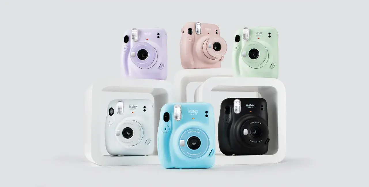 Kolorowe aparaty Instax Mini 11, idealne jako aparat dla dziecka. Różowy, fioletowy, miętowy, niebieski, biały i czarny.