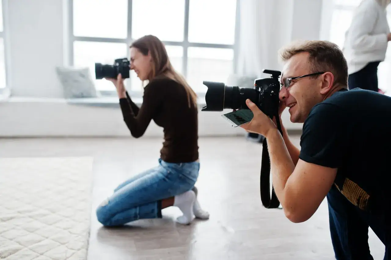Dwoje fotografów, mężczyzna i kobieta, robi zdjęcia. Zastanawiasz się, ile trwa wywołanie zdjęć u fotografa?