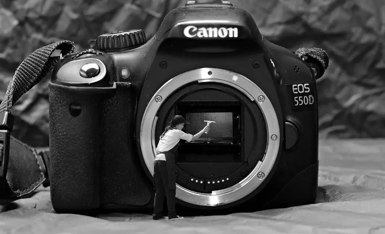 Miniaturka czyści wnętrze aparatu Canon EOS 550D. Zastanawiasz się, gdzie sprzedać aparat fotograficzny?